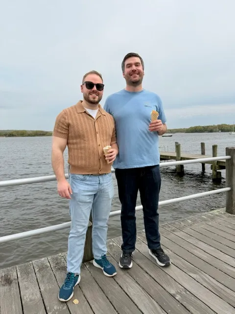 Zack and Mason holding ice cream cones on a wooden dock over the water in Connecticut.